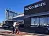 People standing outside a McDonald's with futuristic, UFO-like architecture in Roswell