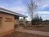 Exterior of Sumner Lake State Park visitor center beside trees and desert landscape.