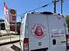 Rear view of a Magic Outdoor Experiences van parked near a Shell gas station sign.