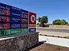 Circle K fuel price sign showing high gas and diesel prices beside a quiet road.