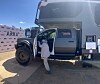 A large Winnebago ARKA adventure truck is parked outdoors while a person steps into the open passenger door.