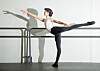 Von Kronberg in a studio extends one leg behind while holding a ballet barre.