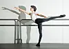 Von Kronberg in a studio extends one leg behind while holding a ballet barre.