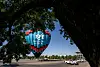 UNM Children’s Hospital balloon Hope Rising stands in a parking lot framed by trees near University Stadium.