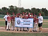 Youth baseball team from Roadrunner Little League in Albuquerque, New Mexico, holding a championship banner on a baseball field.