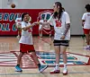 Bella Hines coaching kids inside a basketball gym.