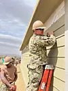 Military members working on Malone house